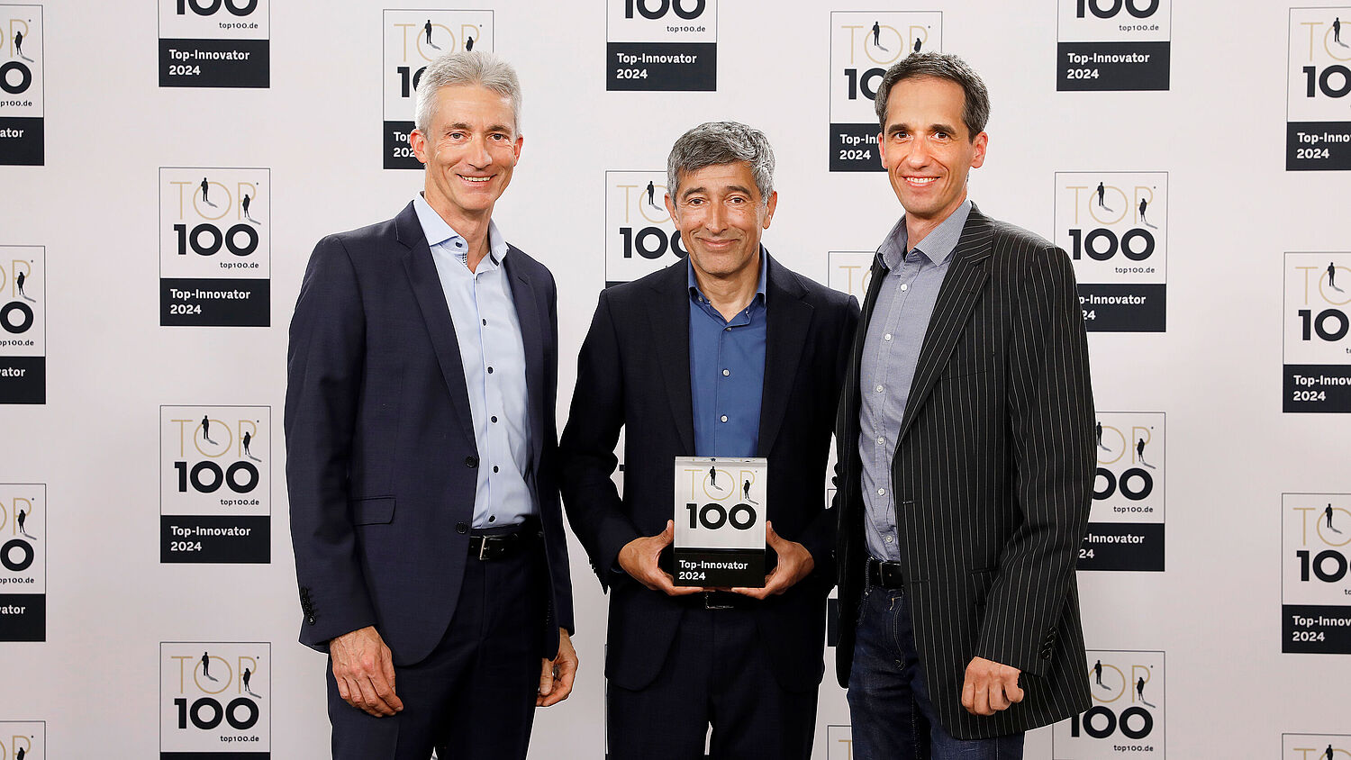 来自 FAULHABER 的 Udo Haberland 博士和 Frank Schwenker 从科学记者 Ranga Yogeshwar 手中接过 TOP100 奖杯