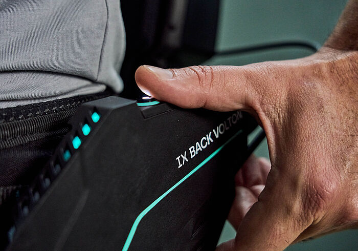 特写镜头：一只手正在操作SUITX公司生产的IX BACK VOLTON外骨骼的控制单元。