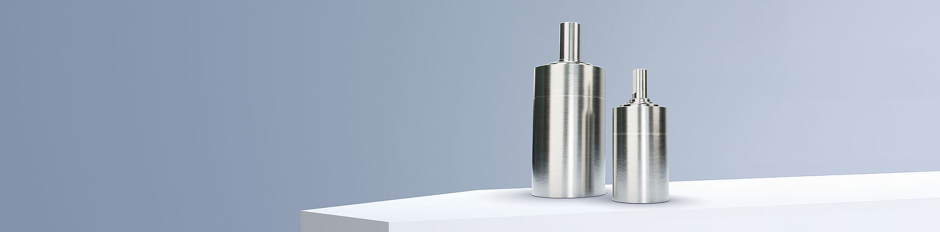 FAULHABER GPT LN 系列的两个行星齿轮减速机排列在灰蓝色背景前的白色台阶上。