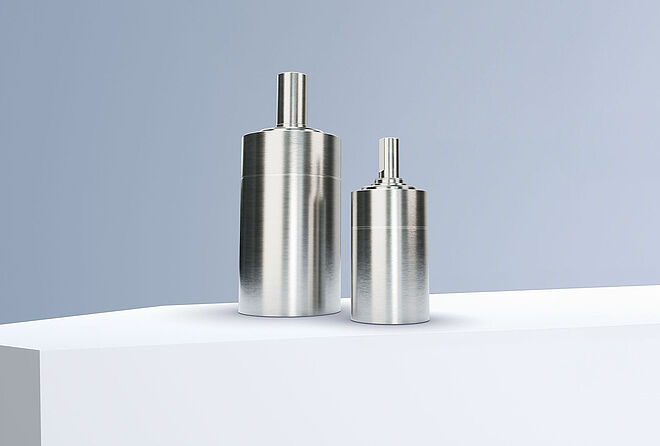 FAULHABER GPT LN 系列的两个行星齿轮减速机排列在灰蓝色背景前的白色台阶上。