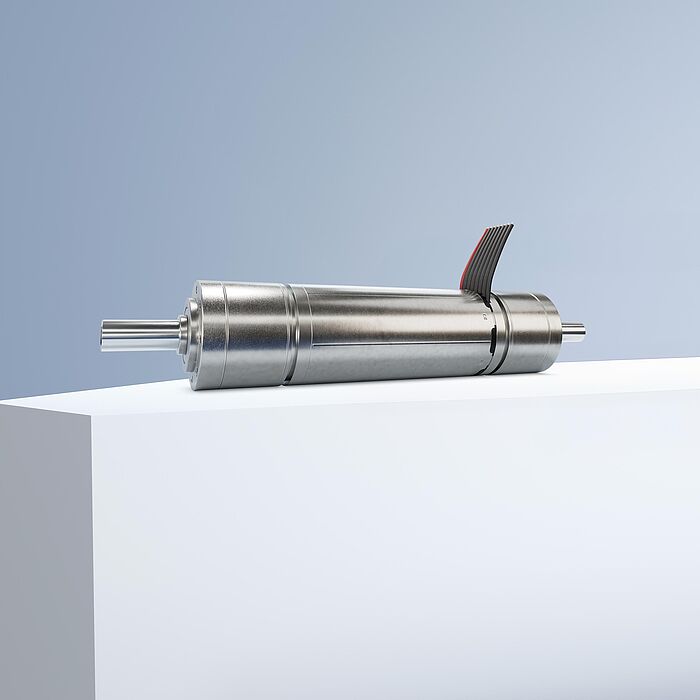 一款FAULHABER品牌的DualGear无刷减速电机，置于灰蓝色背景前的白色台阶上。