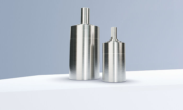 Two planetary gearheads from the FAULHABER GPT LN family arranged on white steps in front of a gray-blue background.