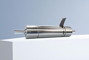 一款FAULHABER品牌的DualGear无刷减速电机，置于灰蓝色背景前的白色台阶上。