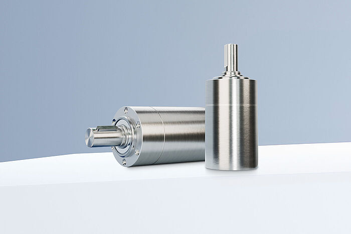 Two planetary gearheads from the FAULHABER GPT HT family arranged on white steps in front of a gray-blue background.