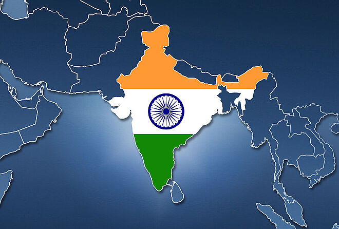 Schematic map in blue tones of Africa and Asia with country borders, in which the area of India is filled in with the Indian flag. The map represents the opening of FAULHABER India Pvt Ltd.