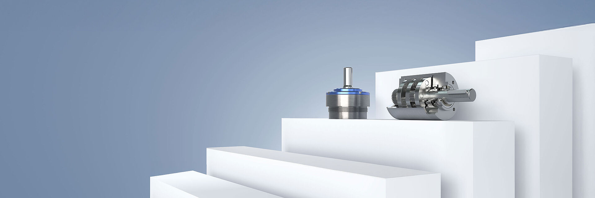 FAULHABER 生产的两个不同的小型齿轮箱，在灰蓝色背景的白色平台上排列。