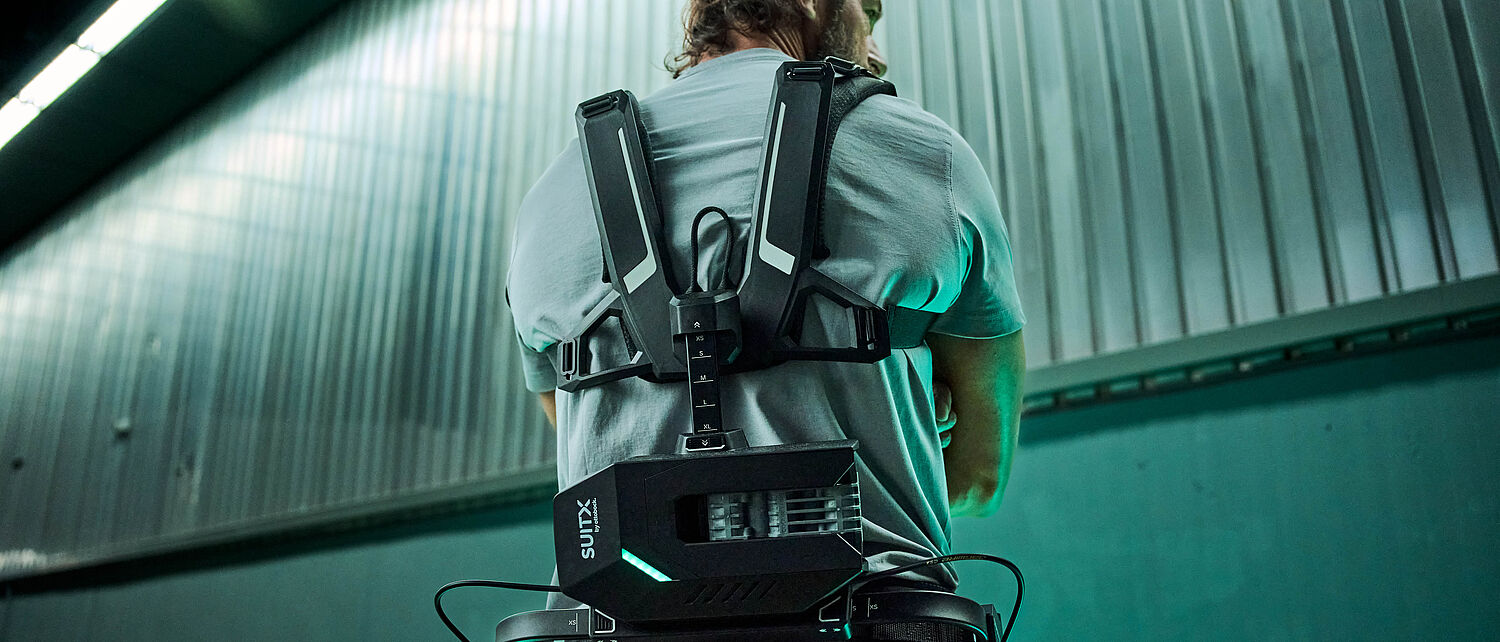 一名仓库工人身穿由SUITX公司研发的IX BACK VOLTON外骨骼，其运动辅助功能由集成的FAULHABER驱动系统提供支持。