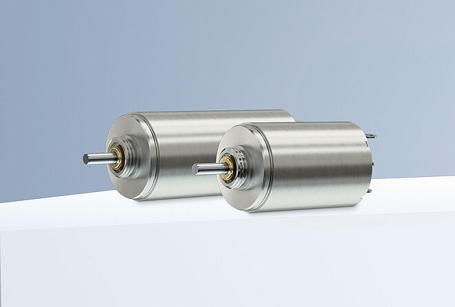 两台 FAULHABER SXR 系列直流电机在灰蓝色背景的白色平台上排列。