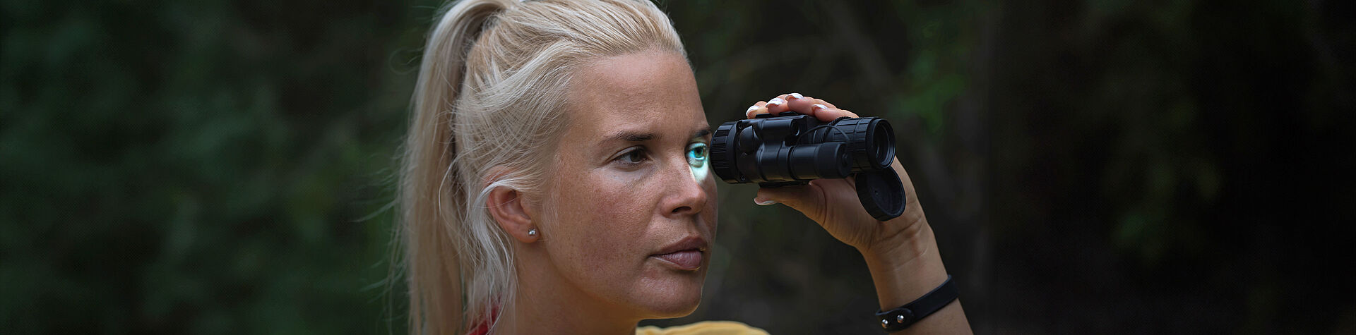 用于夜视仪聚焦和变焦的直流电机 - Header 黄昏时分,一名妇女正透过夜视仪观察四周