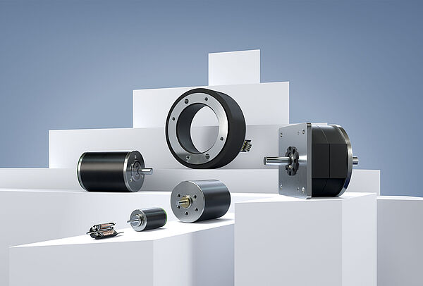 Six different stepper motors from FAULHABER, arranged on white stages against a gray-blue background.